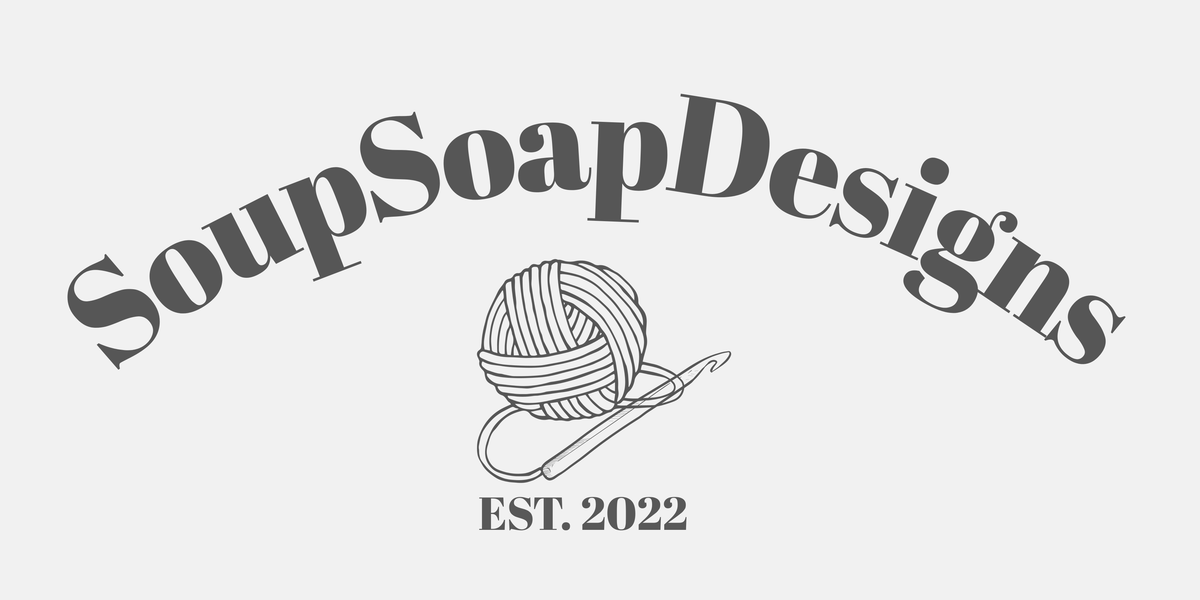 Soup Soap Designs logo featuring stylized text arched over a line drawing of a ball of yarn and crochet hook, with 'EST. 2022' below, on a light gray background.
